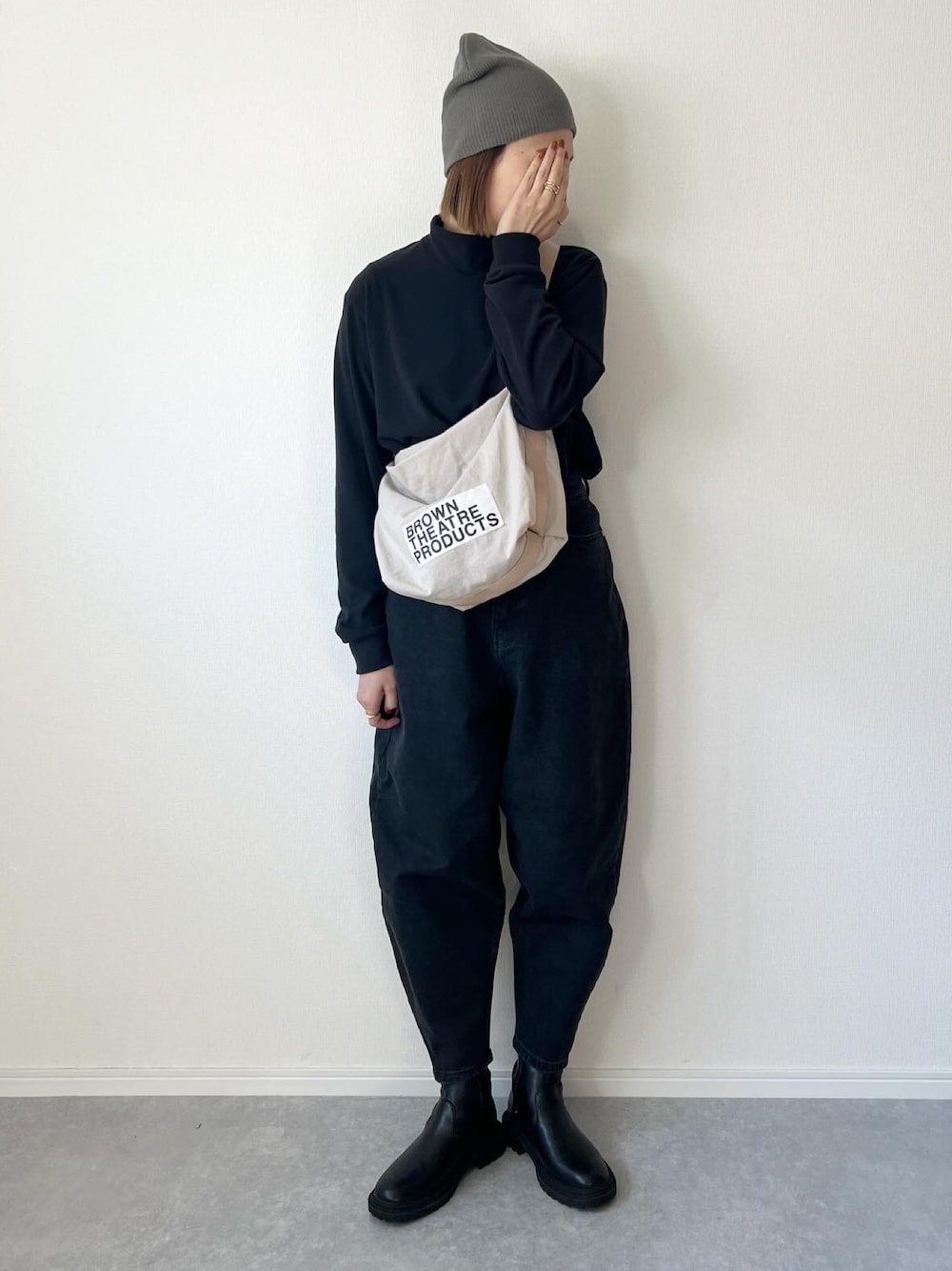 ブラック系のショルダーバッグ、ブラック系のトップス、ブルー系のデニムパンツを着用したレディースの冬コーディネートの1枚目の写真