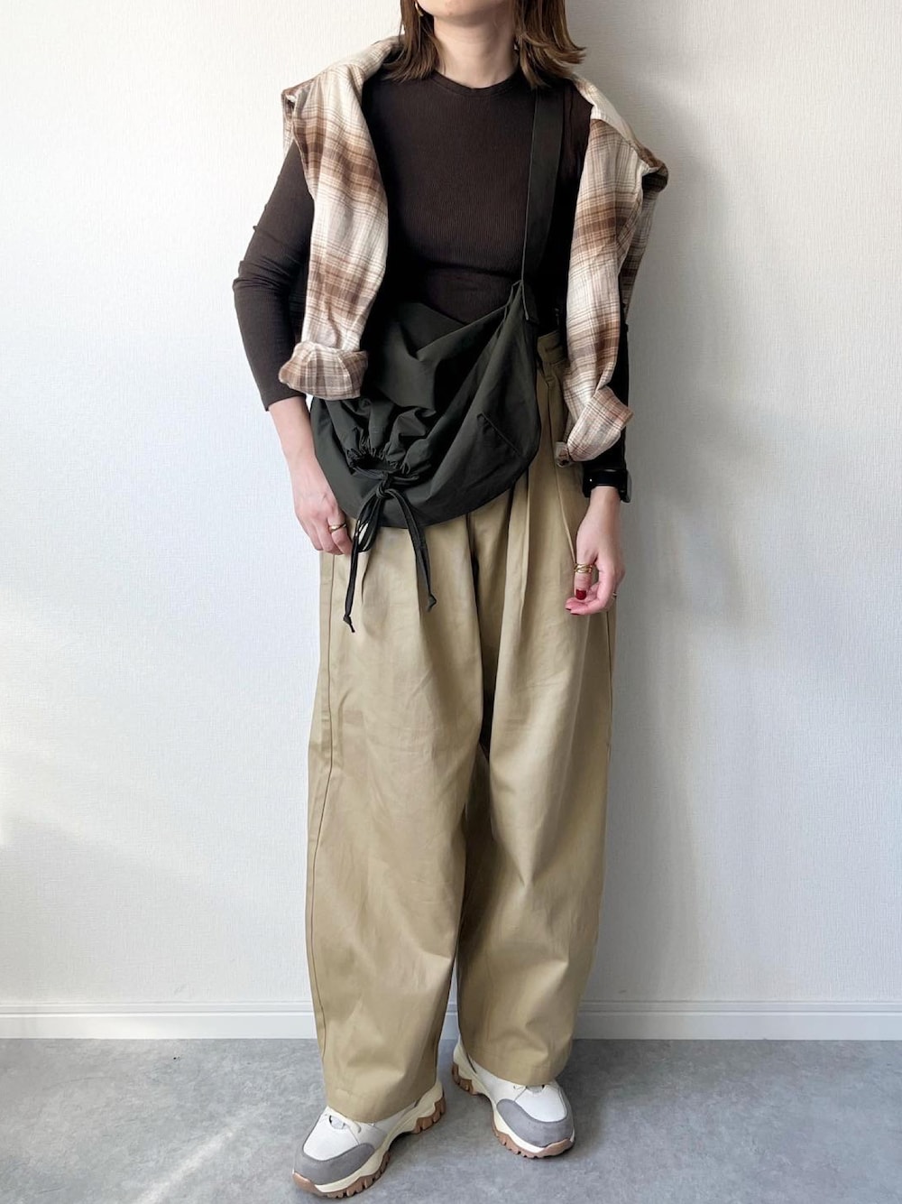 ブラウン系のTシャツ/カットソー、グリーン系のショルダーバッグ、ベージュ系のチノパンツを着用したレディースの秋コーディネートの1枚目の写真