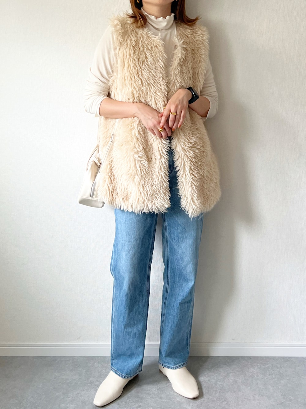 ホワイト系のベスト、ホワイト系のTシャツ/カットソー、ホワイト系のショルダーバッグを着用したレディースの秋コーディネートの1枚目の写真