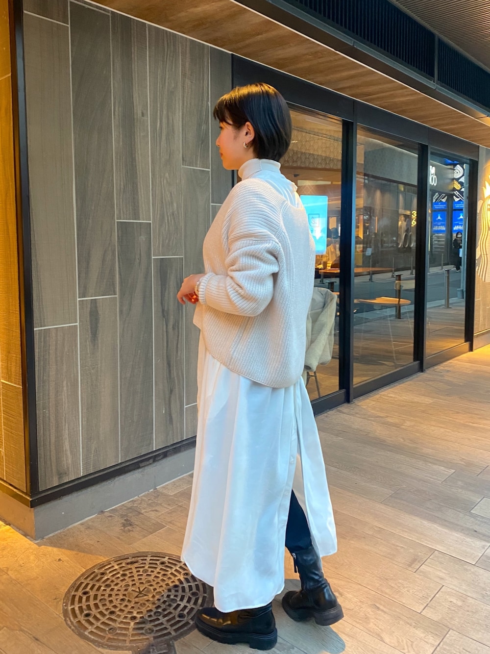 ホワイト系のニット/セーター、ホワイト系のワンピース、ベージュ系のTシャツ/カットソーを着用したレディースの冬コーディネートの2枚目の写真