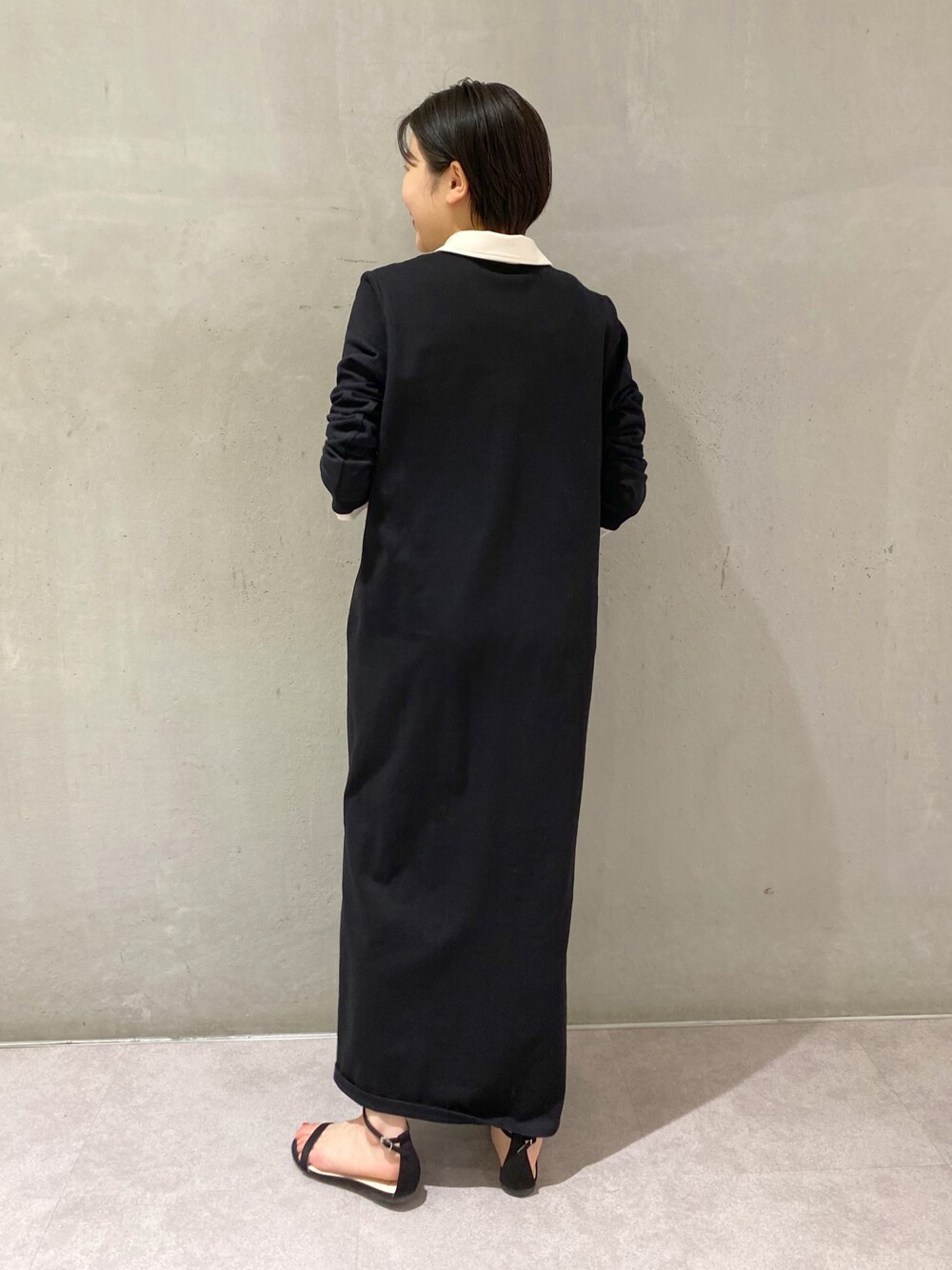 ブラック系のワンピースを着用したレディースの春コーディネートの2枚目の写真