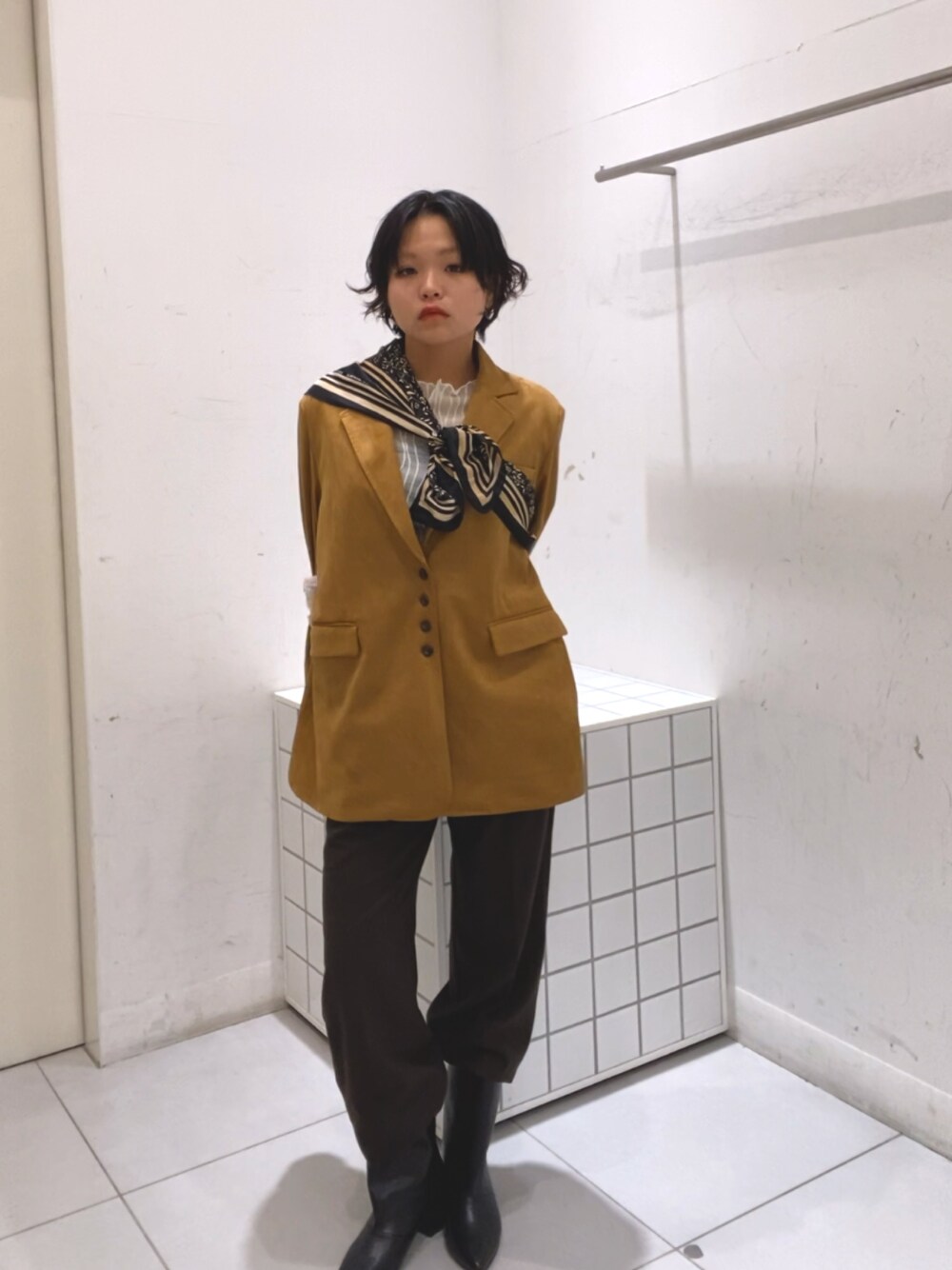 イエロー系のその他アウター、ブラウン系のその他パンツ、ブラック系のブーツを着用したレディースの秋コーディネートの1枚目の写真