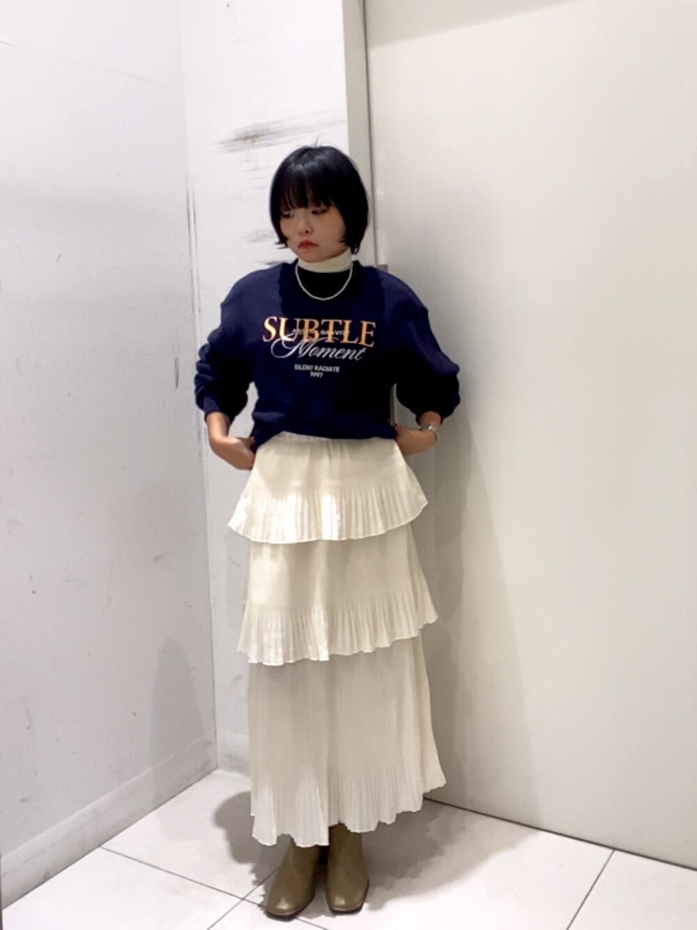 ホワイト系のスカート、ホワイト系のTシャツ/カットソー、ベージュ系のスウェットを着用したレディースの秋コーディネートの1枚目の写真