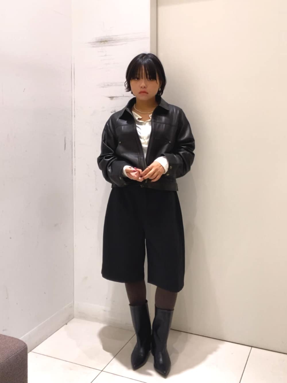 ブラック系のその他アウター、ブラック系のその他パンツ、ホワイト系のTシャツ/カットソーを着用したレディースの秋コーディネートの1枚目の写真