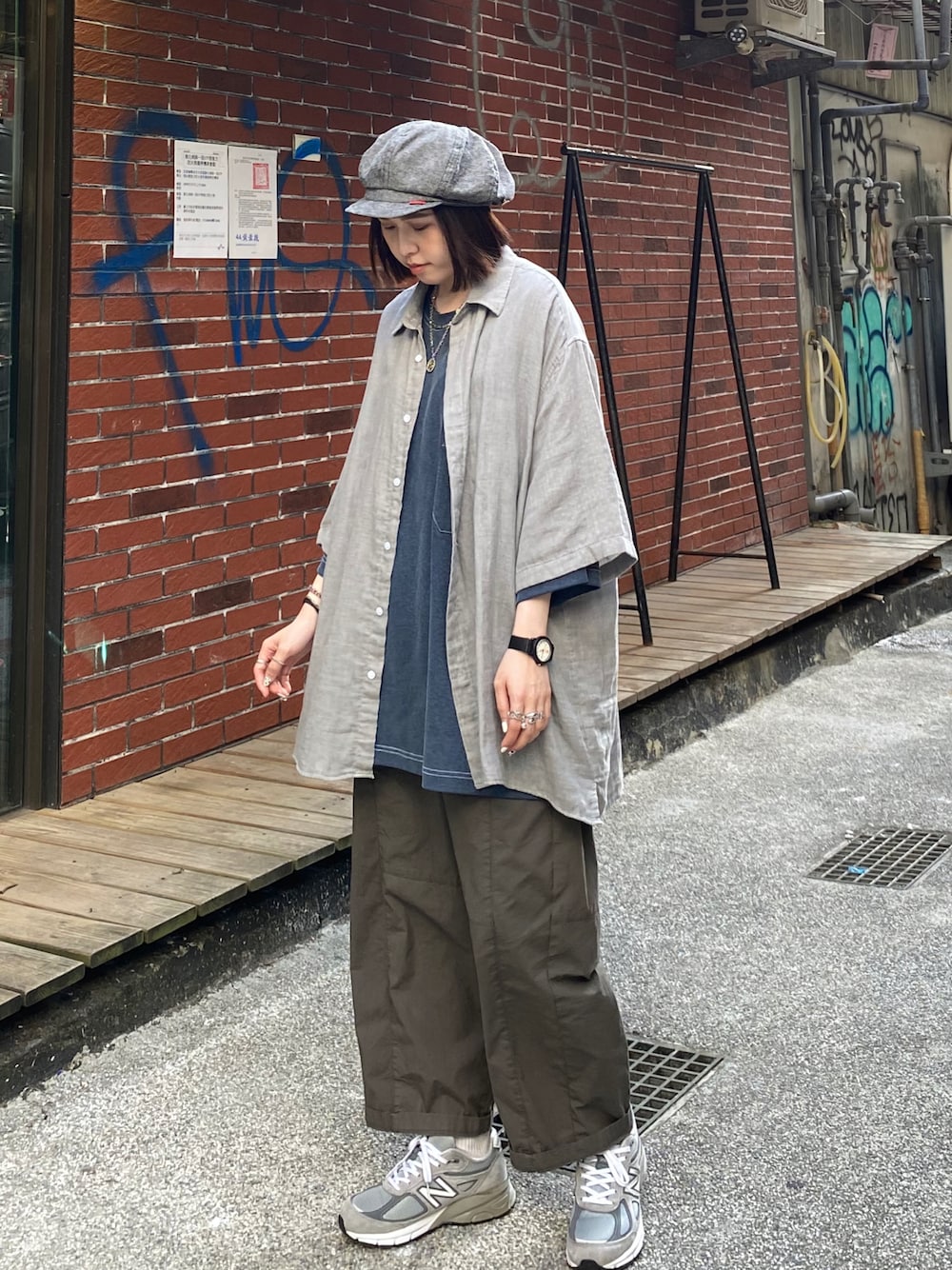 グレー系のスニーカー、グレー系のキャスケットを着用したレディースの夏コーディネートの1枚目の写真