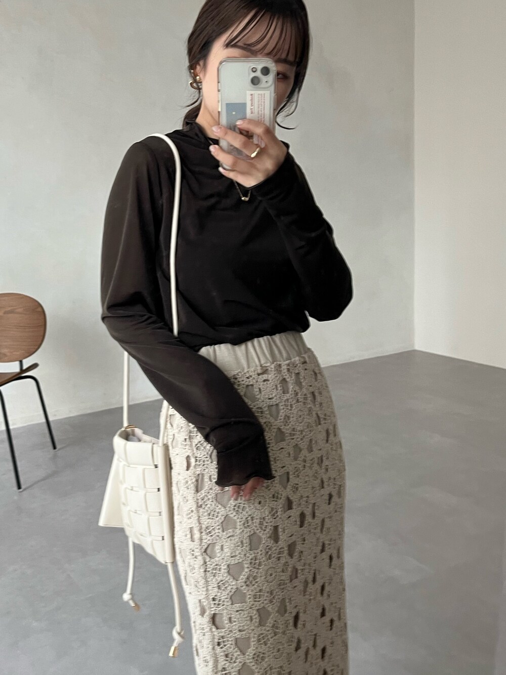 グレー系のTシャツ/カットソー、ホワイト系のショルダーバッグ、ホワイト系のスカートを着用したレディースの冬コーディネートの3枚目の写真