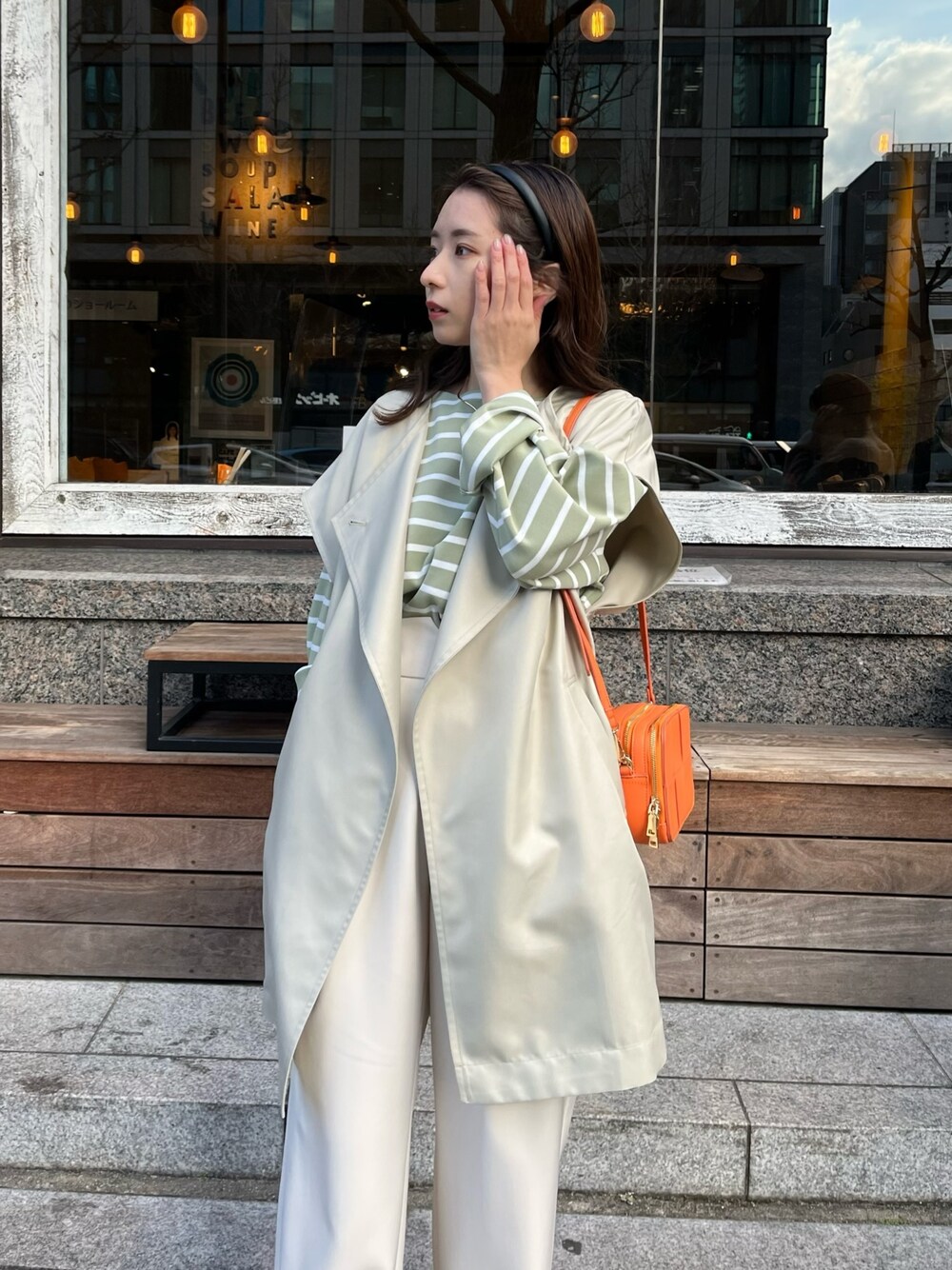 グリーン系のニット/セーター、ベージュ系のベスト、オレンジ系のショルダーバッグを着用したレディースの冬コーディネートの4枚目の写真