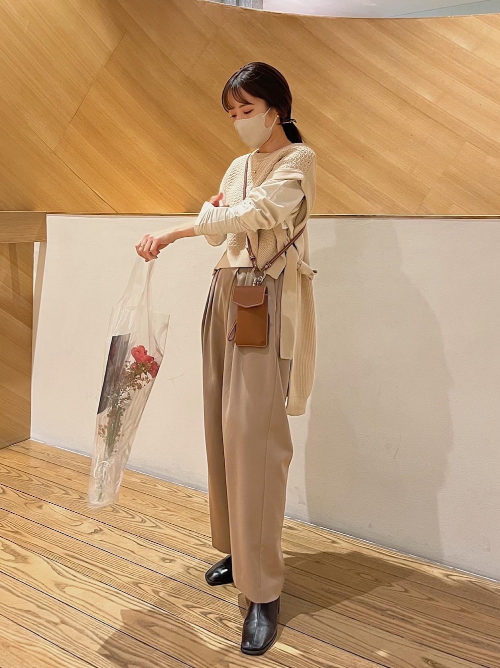 ベージュ系のベスト、ベージュ系のモッズコート、ブラウン系のショルダーバッグを着用したレディースの春コーディネートの4枚目の写真