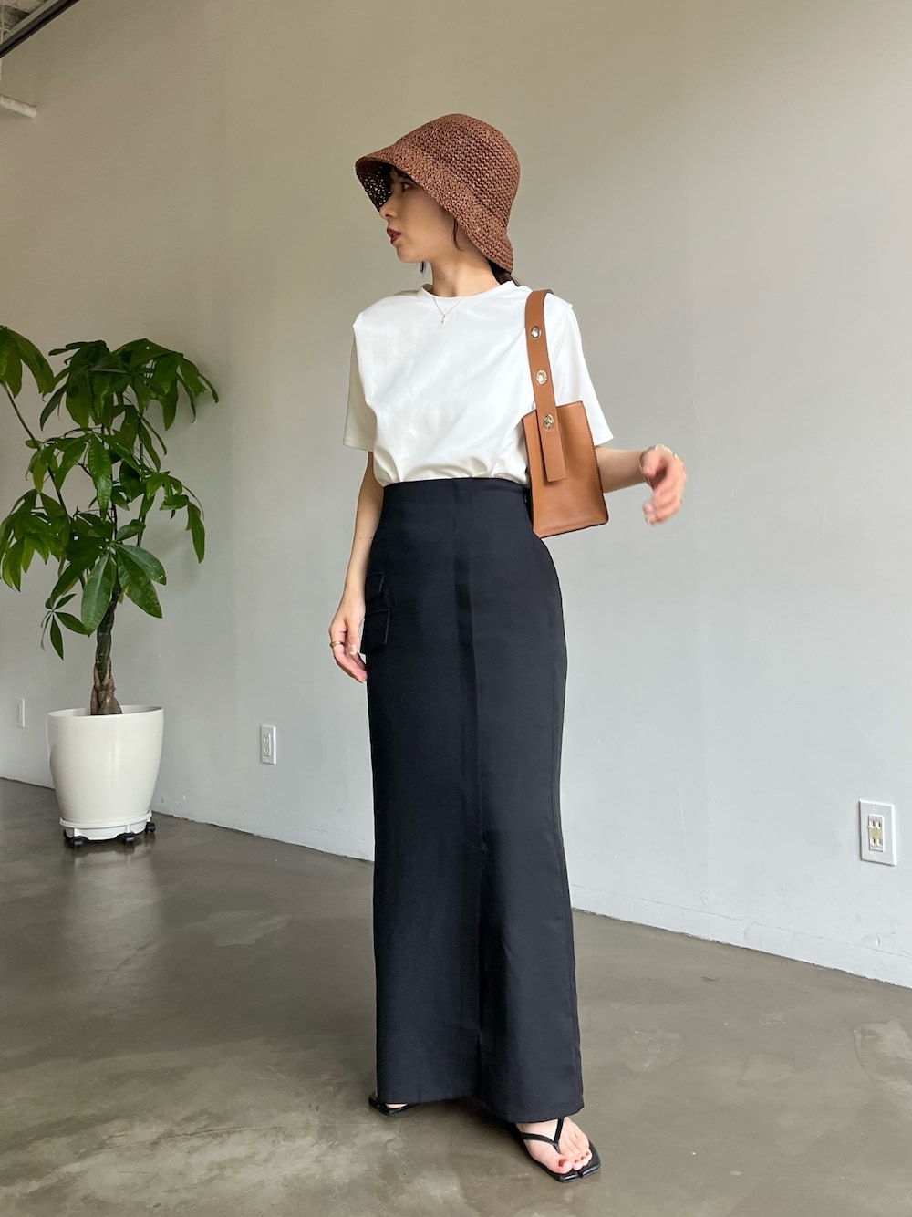ホワイト系のTシャツ/カットソー、ブラック系のスカート、ブラウン系のハットを着用したレディースの春コーディネートの3枚目の写真