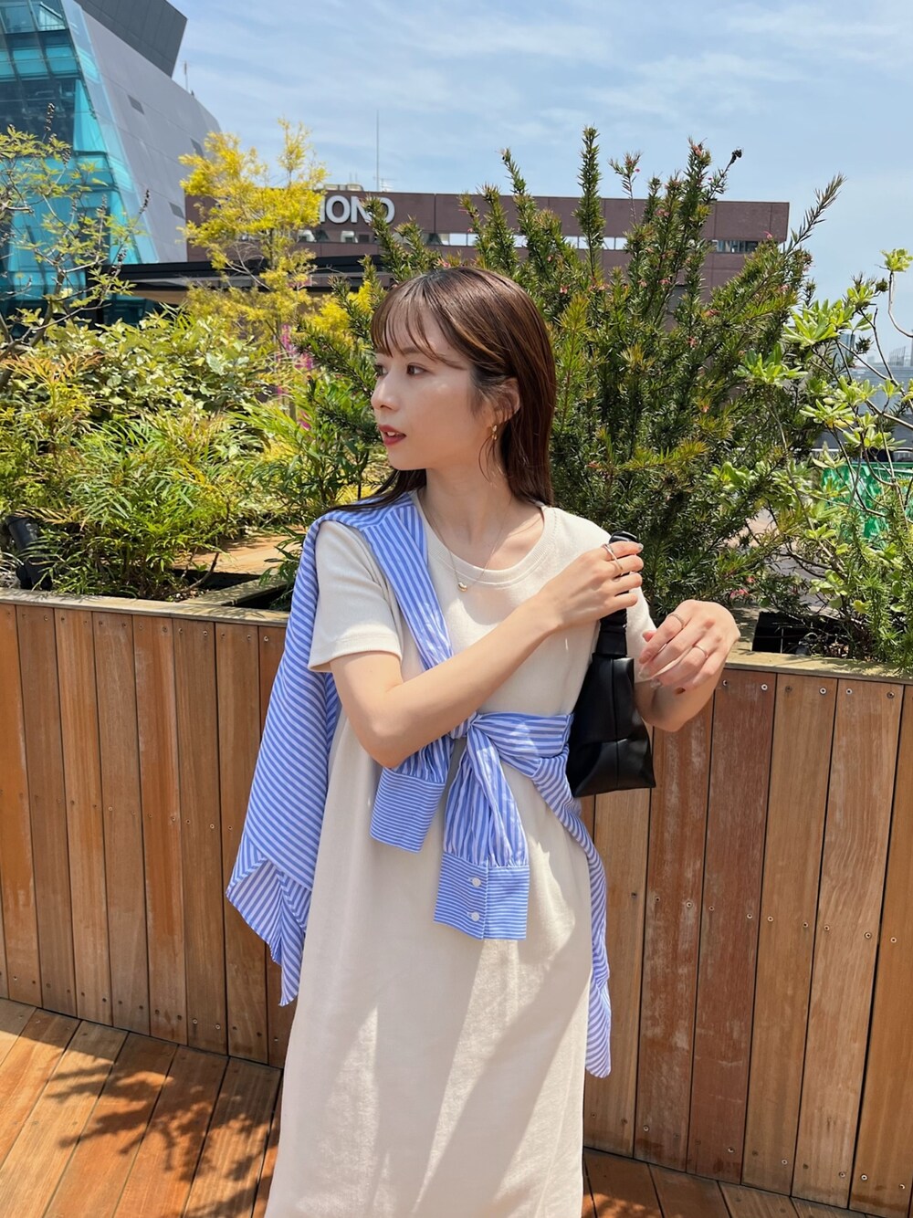 ホワイト系のワンピース、ブルー系のシャツ/ブラウス、ホワイト系のサンダルを着用したレディースの春コーディネートの4枚目の写真