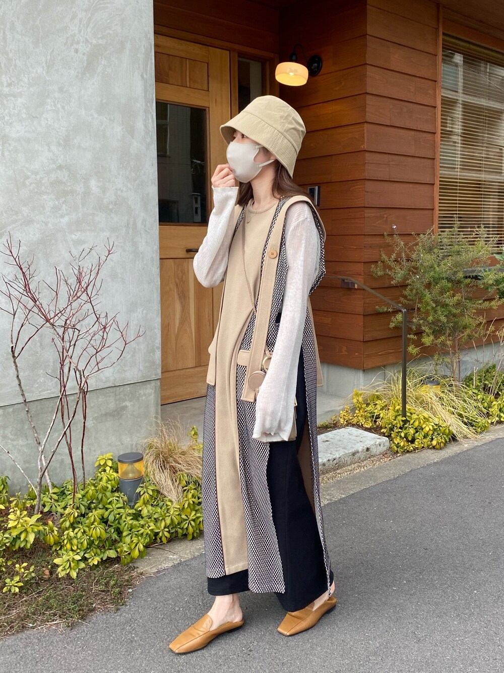 ホワイト系のニット/セーター、ブラック系のスカート、イエロー系のその他シューズを着用したレディースの春コーディネートの2枚目の写真