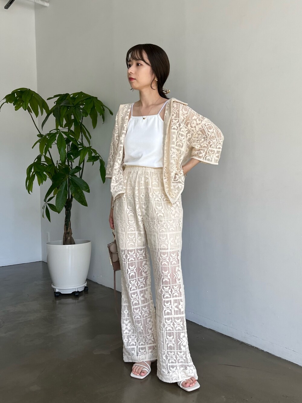 ホワイト系のシャツ/ブラウス、ホワイト系のその他パンツ、ブラウン系のトートバッグを着用したレディースの春コーディネートの2枚目の写真