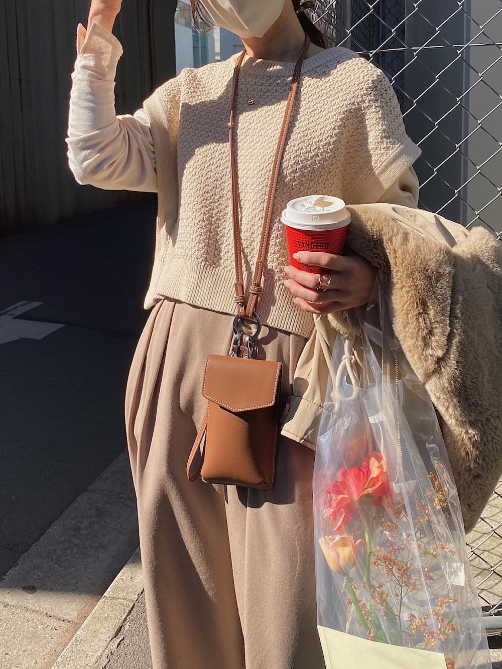 ベージュ系のベスト、ベージュ系のモッズコート、ブラウン系のショルダーバッグを着用したレディースの春コーディネートの3枚目の写真