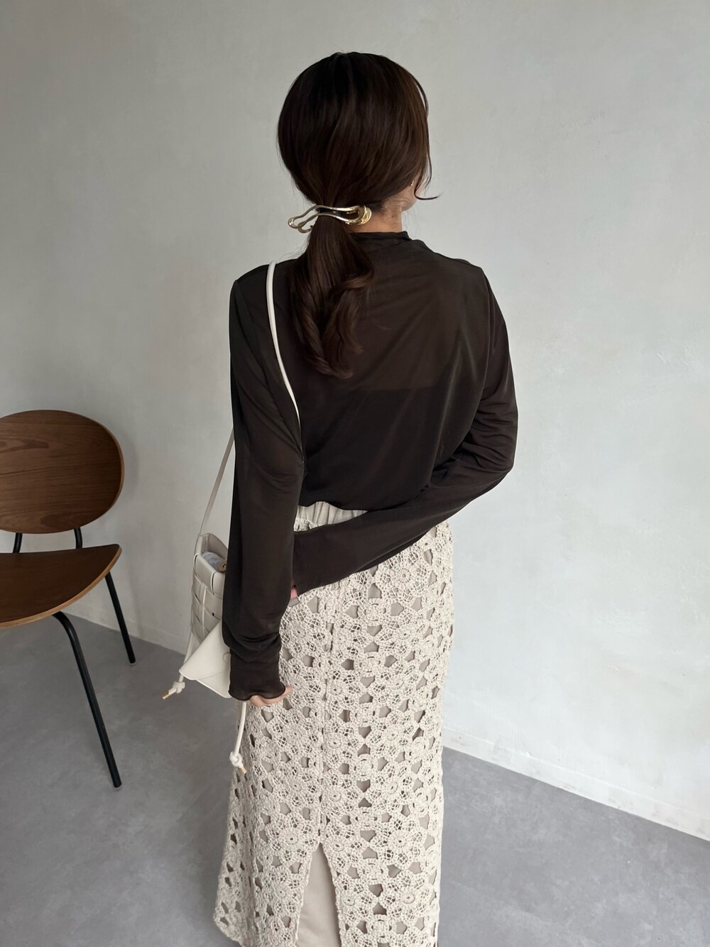 グレー系のTシャツ/カットソー、ホワイト系のショルダーバッグ、ホワイト系のスカートを着用したレディースの冬コーディネートの5枚目の写真