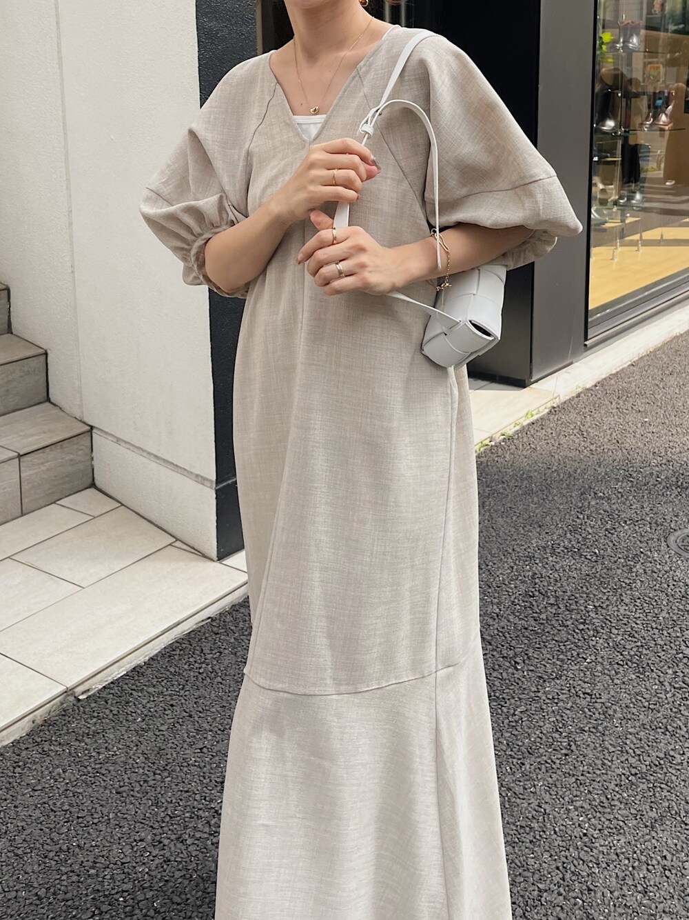 ベージュ系のワンピース、ホワイト系のトートバッグ、ブラック系のサンダルを着用したレディースの夏コーディネートの4枚目の写真