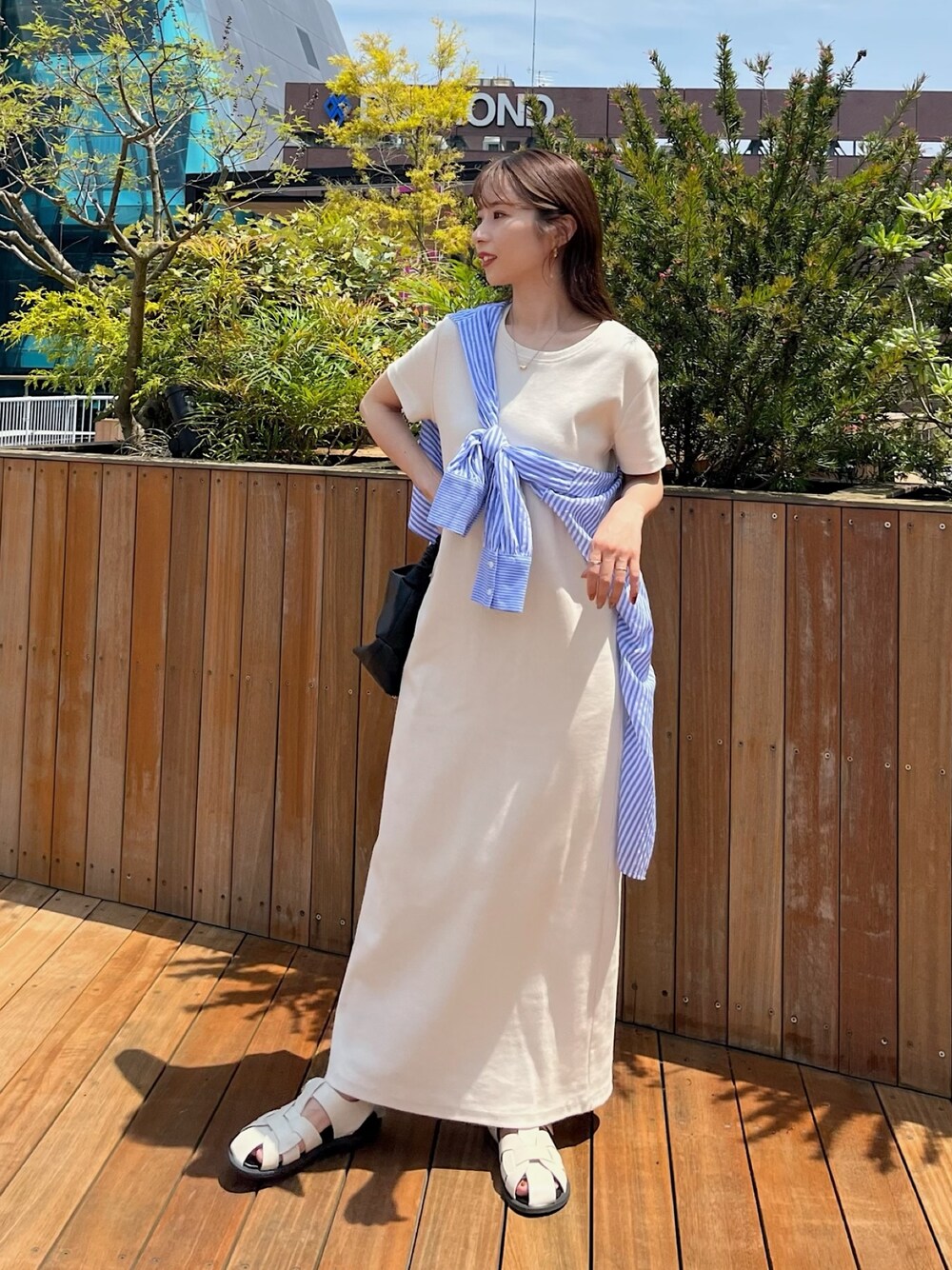 ホワイト系のワンピース、ブルー系のシャツ/ブラウス、ホワイト系のサンダルを着用したレディースの春コーディネートの2枚目の写真