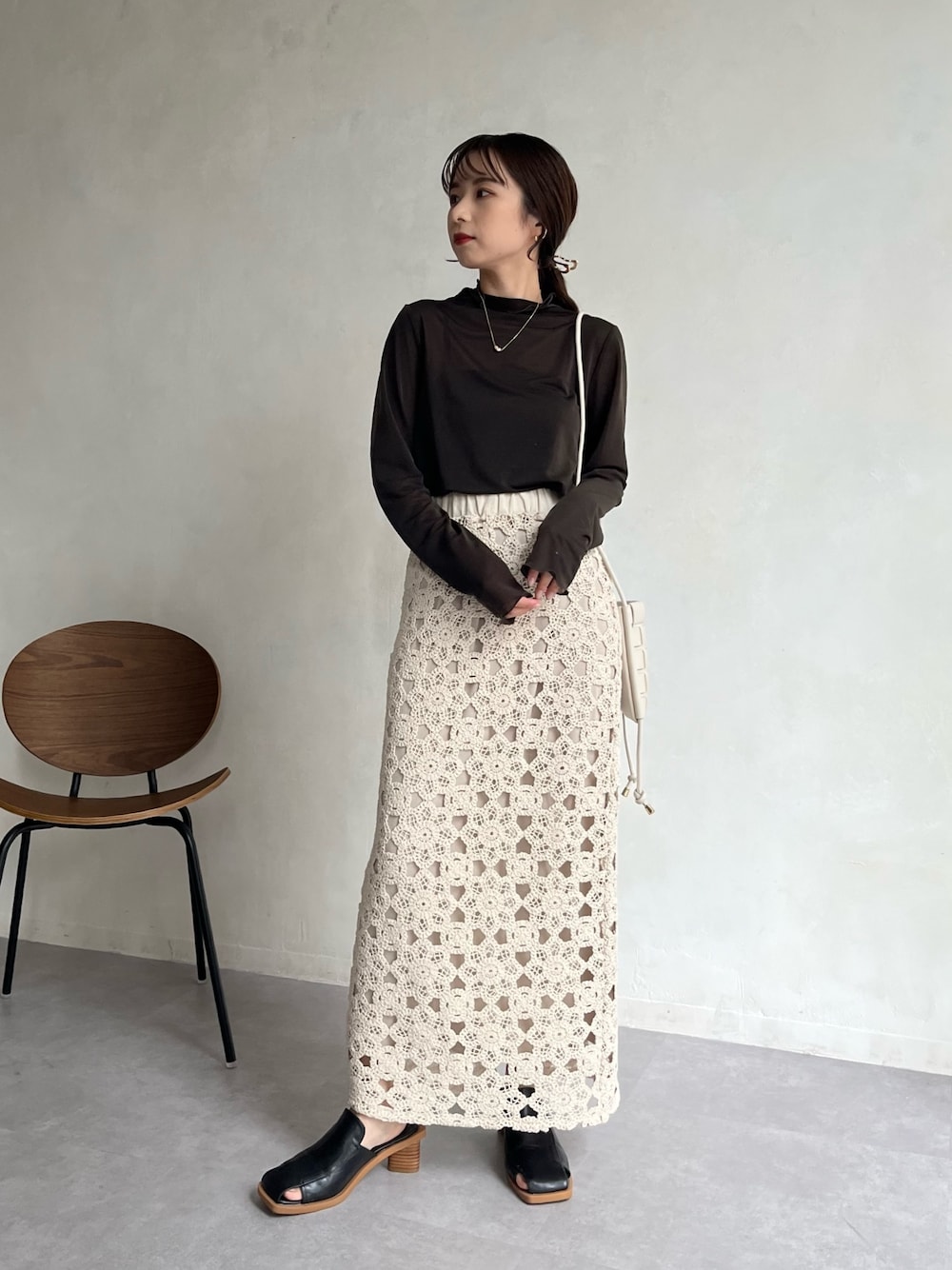 グレー系のTシャツ/カットソー、ホワイト系のショルダーバッグ、ホワイト系のスカートを着用したレディースの冬コーディネートの2枚目の写真