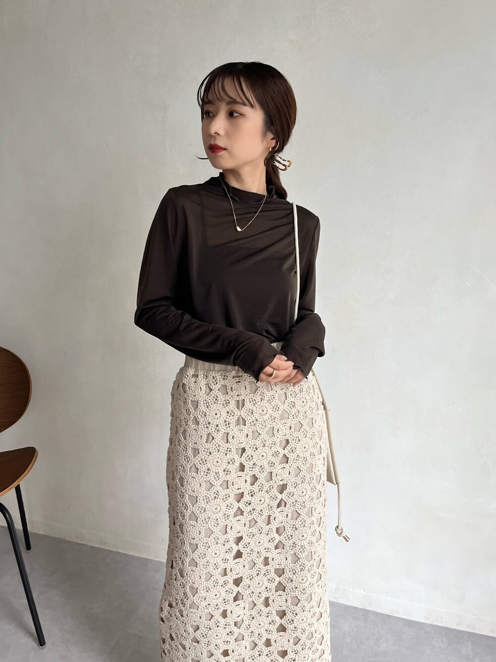 グレー系のTシャツ/カットソー、ホワイト系のショルダーバッグ、ホワイト系のスカートを着用したレディースの冬コーディネートの4枚目の写真