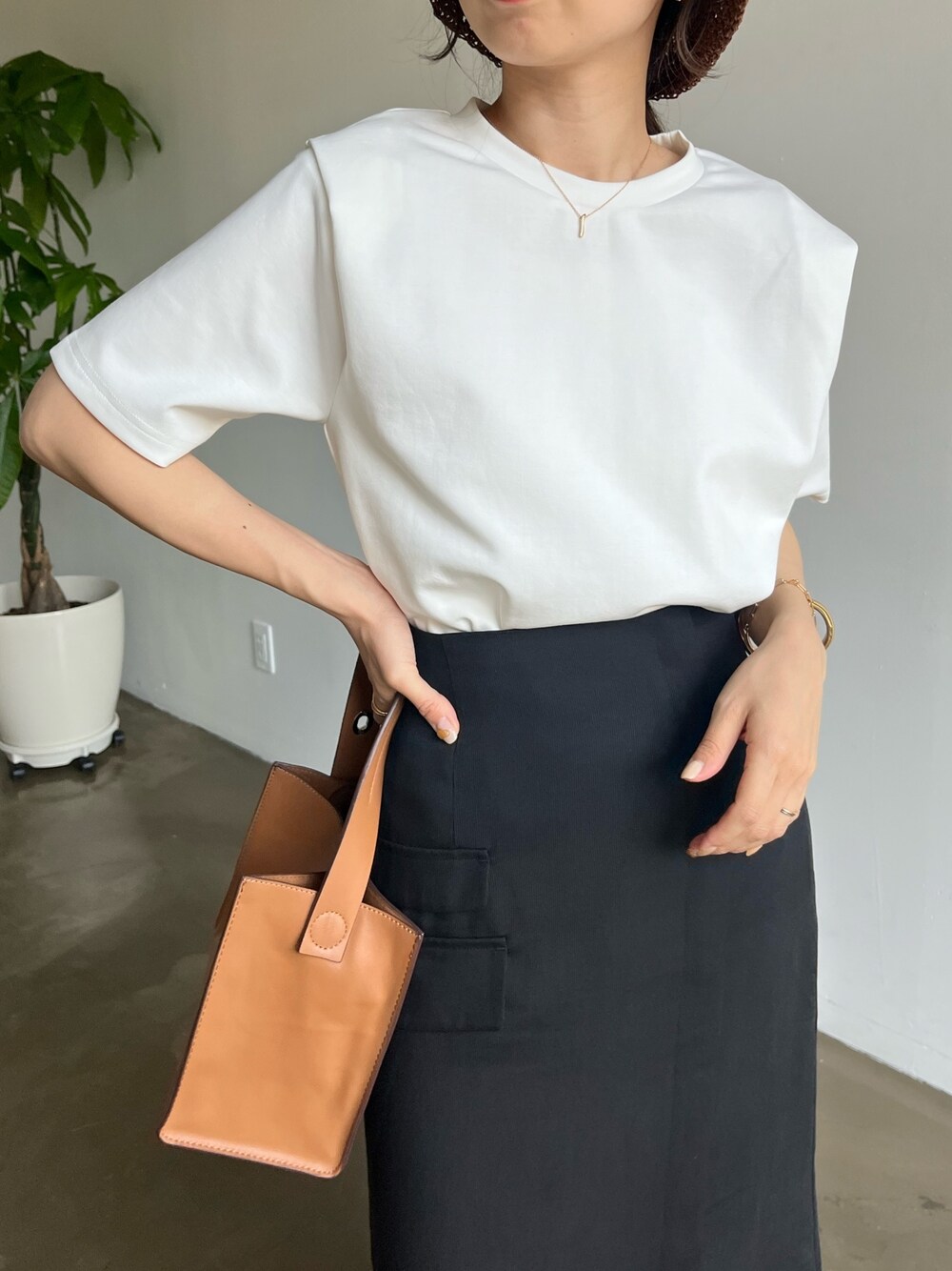 ホワイト系のTシャツ/カットソー、ブラック系のスカート、ブラウン系のハットを着用したレディースの春コーディネートの5枚目の写真