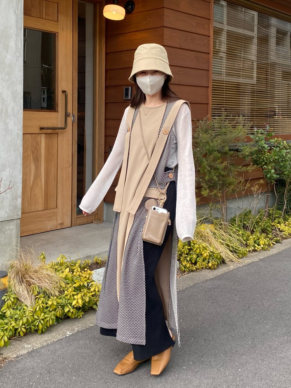 ホワイト系のニット/セーター、ブラック系のスカート、イエロー系のその他シューズを着用したレディースの春コーディネートの3枚目の写真