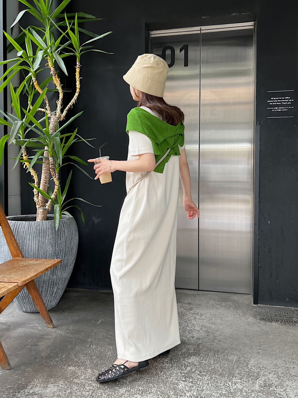 ホワイト系のワンピース、グリーン系のカーディガン/ボレロ、ブラック系のパンプスを着用したレディースの春コーディネートの3枚目の写真