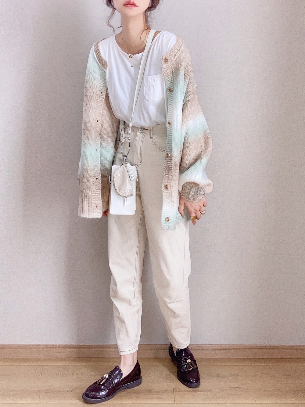 グリーン系のカーディガン/ボレロ、ベージュ系のデニムパンツ、ブラウン系のローファーを着用したレディースの秋コーディネートの1枚目の写真