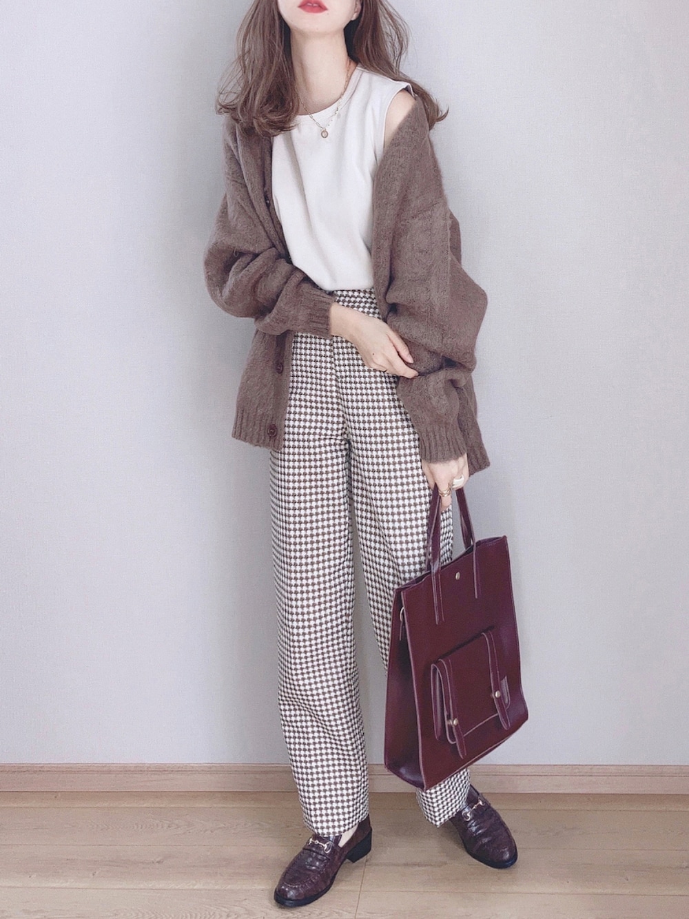 ブラウン系のカーディガン/ボレロ、ベージュ系のスラックス、ブラウン系のローファーを着用したレディースの秋コーディネートの1枚目の写真