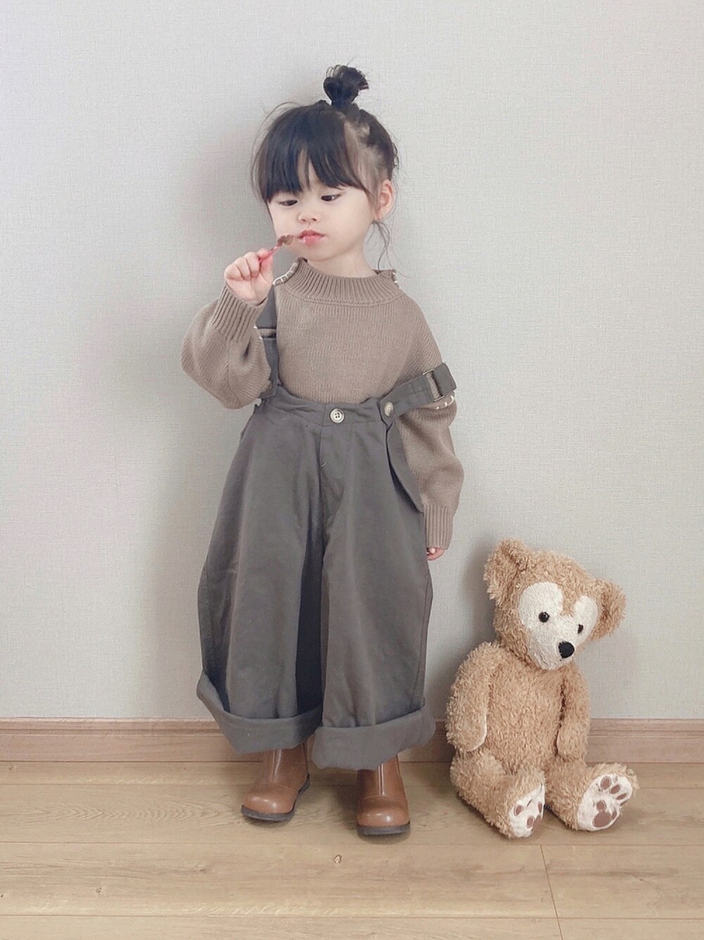 ブラウン系のニット/セーター、グレー系のその他パンツ、ブラウン系のブーツを着用したキッズの秋コーディネートの1枚目の写真