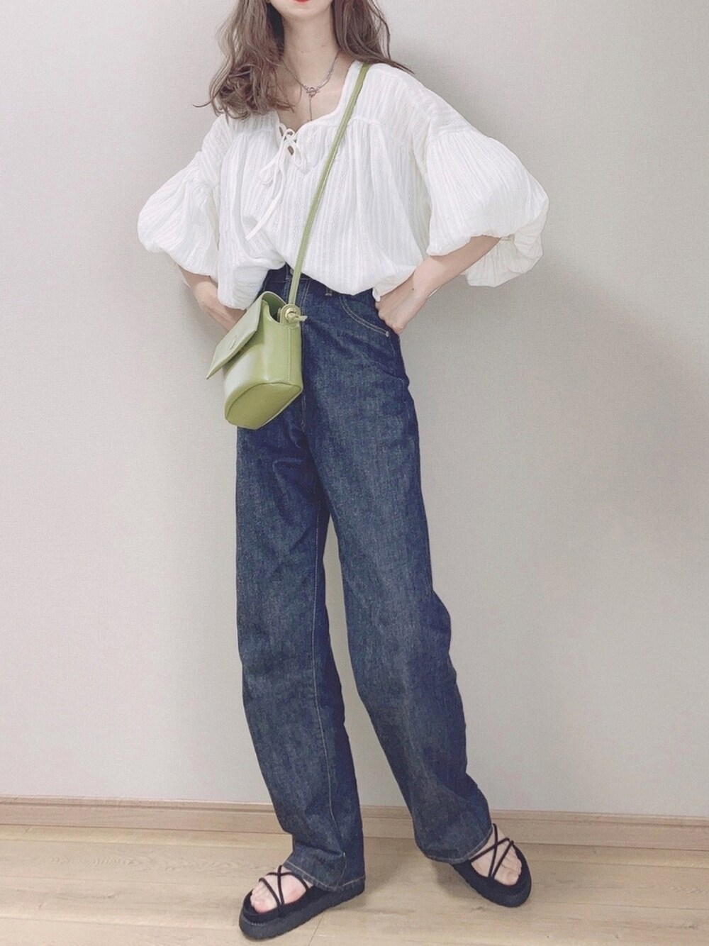 ホワイト系のシャツ/ブラウス、ブルー系のデニムパンツ、グリーン系のショルダーバッグを着用したレディースの春コーディネートの1枚目の写真