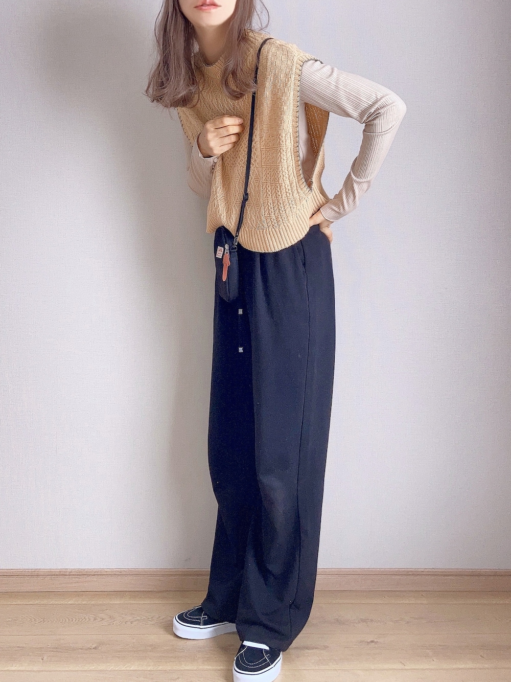 イエロー系のベスト、ベージュ系のTシャツ/カットソー、ブラック系のその他パンツを着用したレディースの秋コーディネートの1枚目の写真