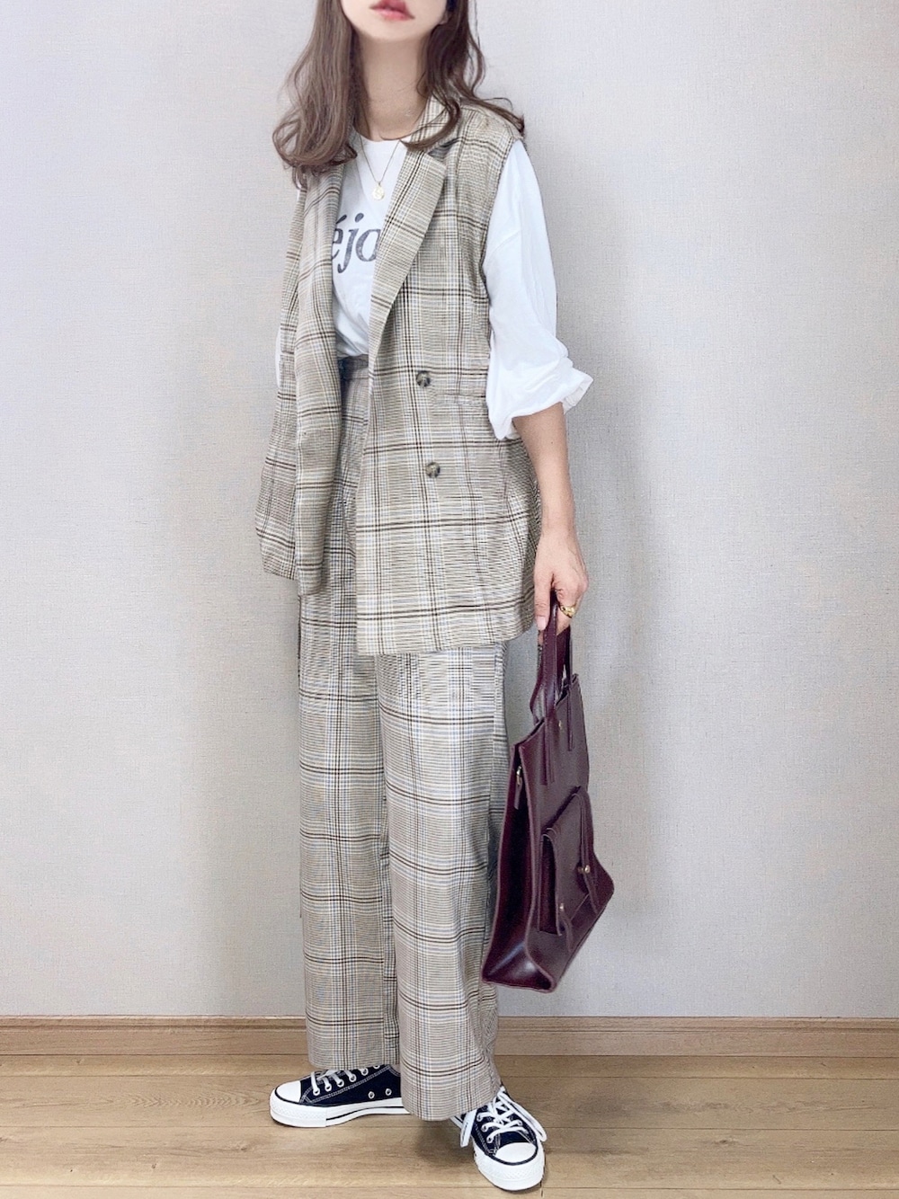 ベージュ系のベスト、ベージュ系のチノパンツ、ホワイト系のTシャツ/カットソーを着用したレディースの秋コーディネートの1枚目の写真