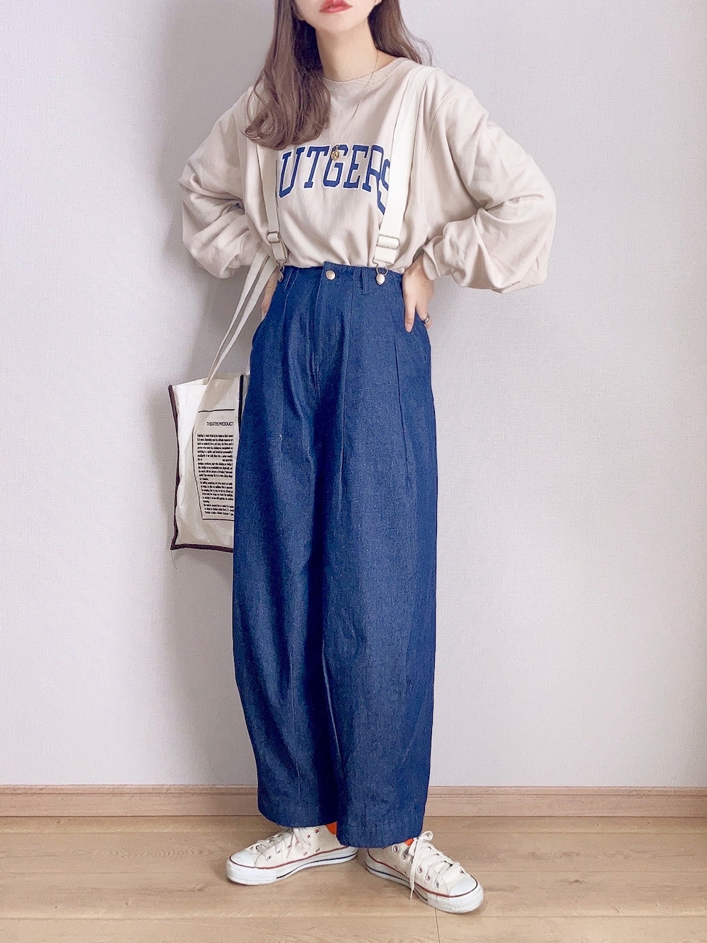 ブルー系のデニムパンツ、ホワイト系のスウェット、ベージュ系のトートバッグを着用したレディースの冬コーディネートの1枚目の写真