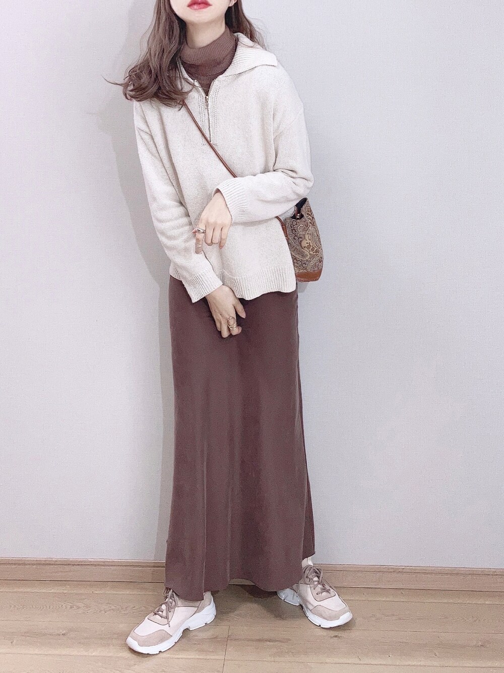 ピンク系のスニーカー、ホワイト系のニット/セーター、ブラウン系のニット/セーターを着用したレディースの冬コーディネートの1枚目の写真