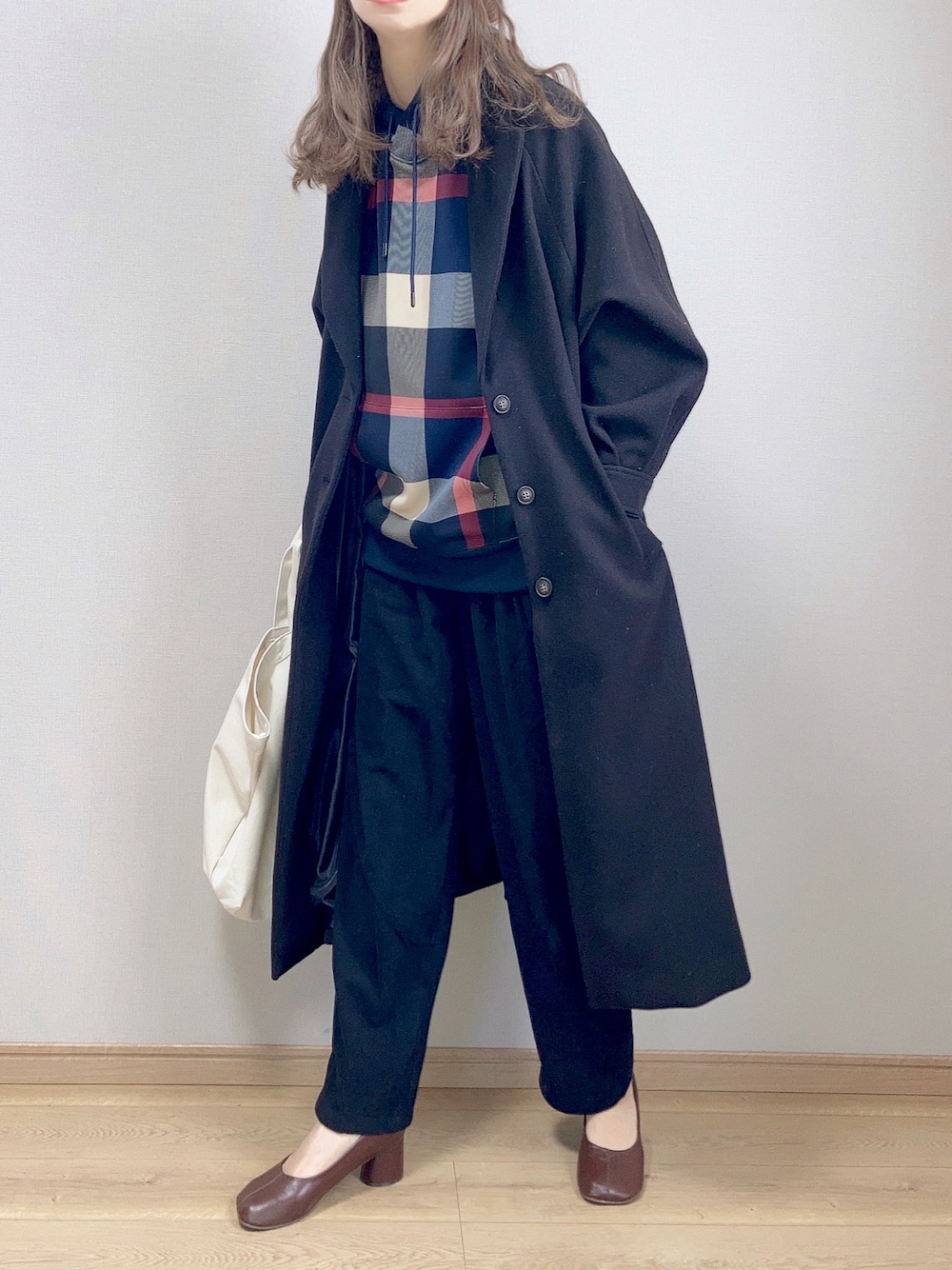 ブルー系のパーカー、ブラック系のチェスターコート、ブラック系のその他パンツを着用したレディースの冬コーディネートの1枚目の写真