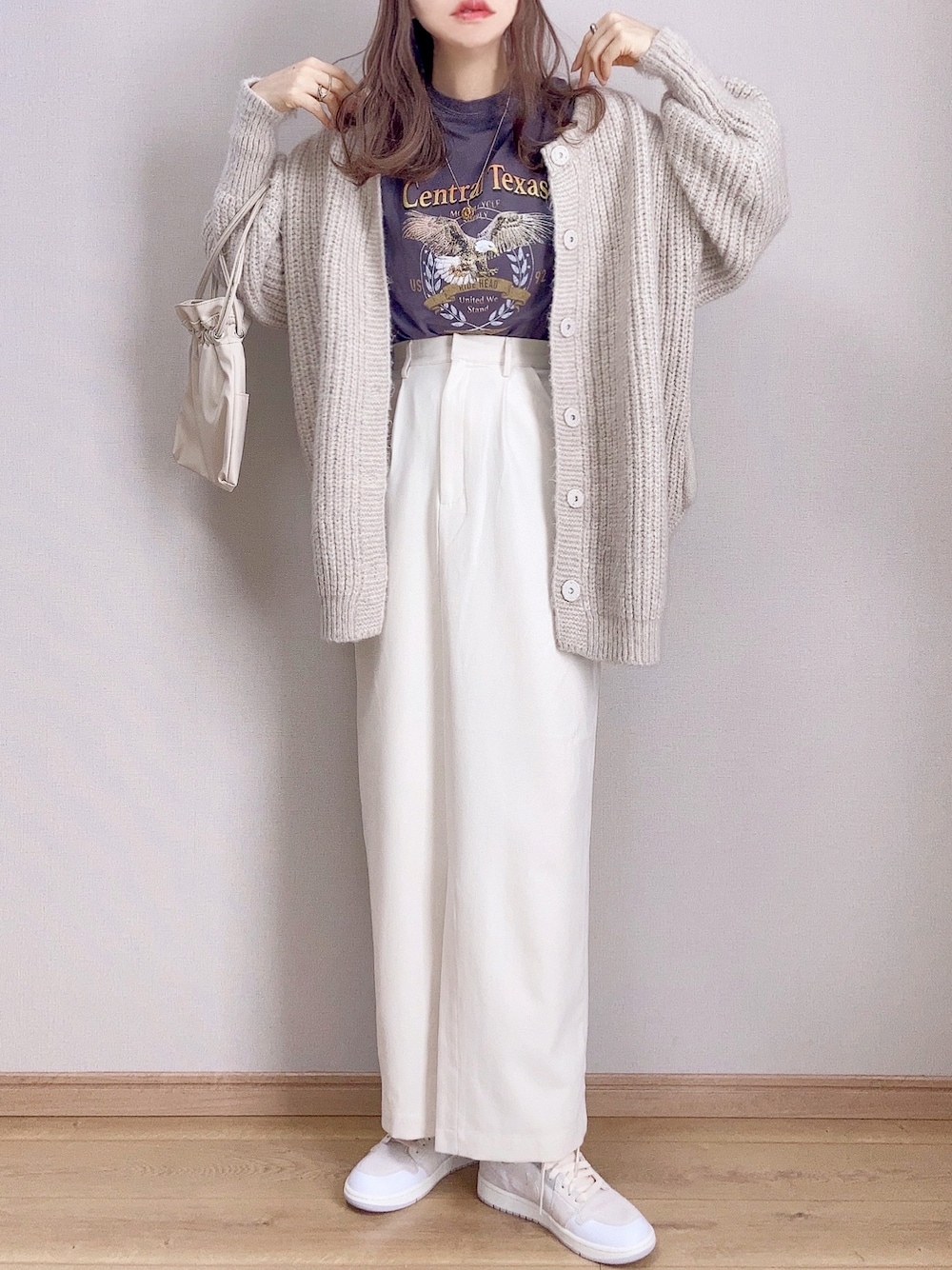 ブラック系のTシャツ/カットソー、ホワイト系のカーディガン/ボレロ、ホワイト系のスカートを着用したレディースの冬コーディネートの1枚目の写真