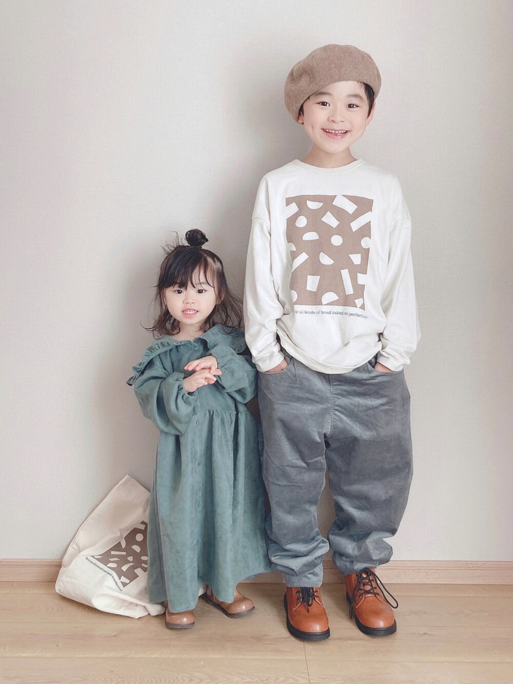 ホワイト系のTシャツ/カットソー、グリーン系のその他パンツ、イエロー系のブーツを着用したキッズの秋コーディネートの1枚目の写真