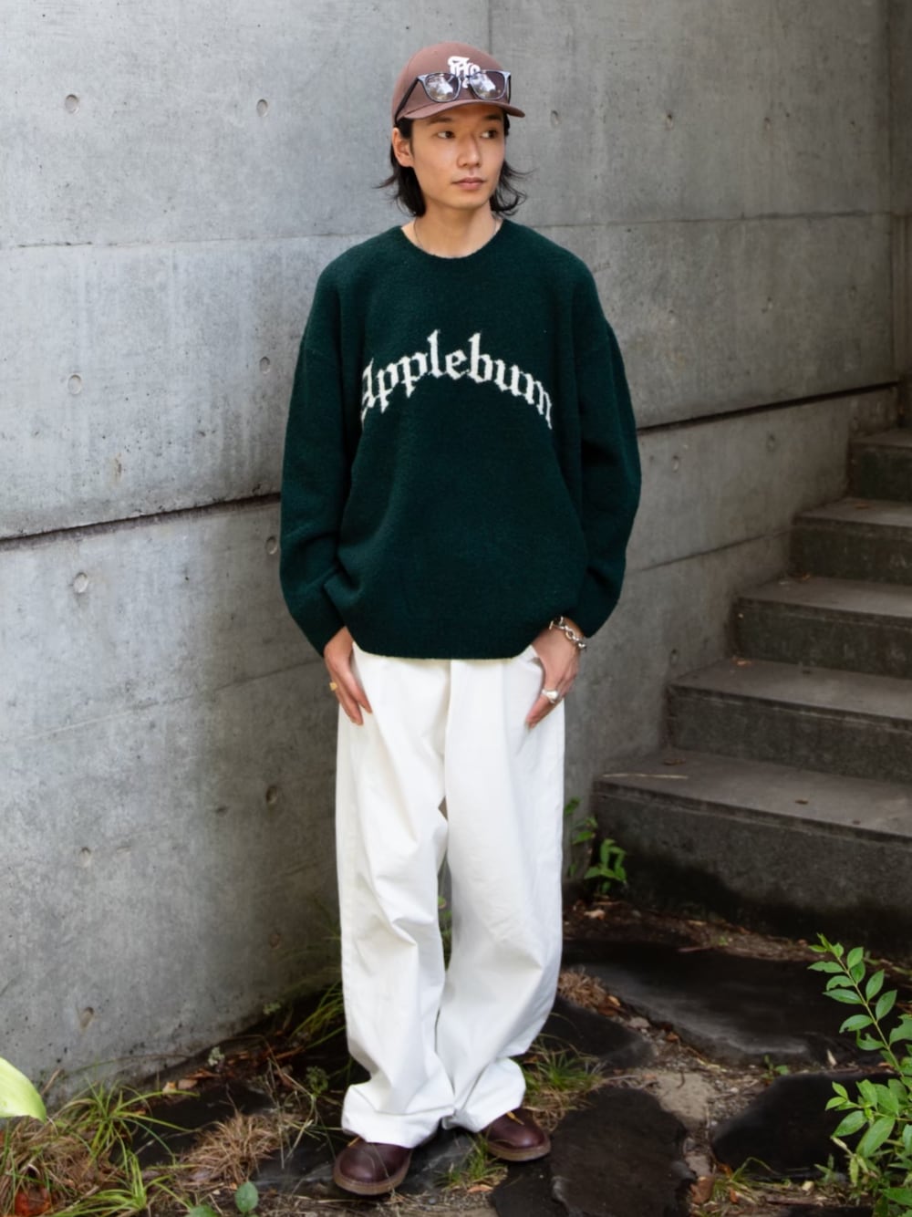 グリーン系のニット/セーター、ブラウン系のキャップを着用したメンズの冬コーディネートの1枚目の写真