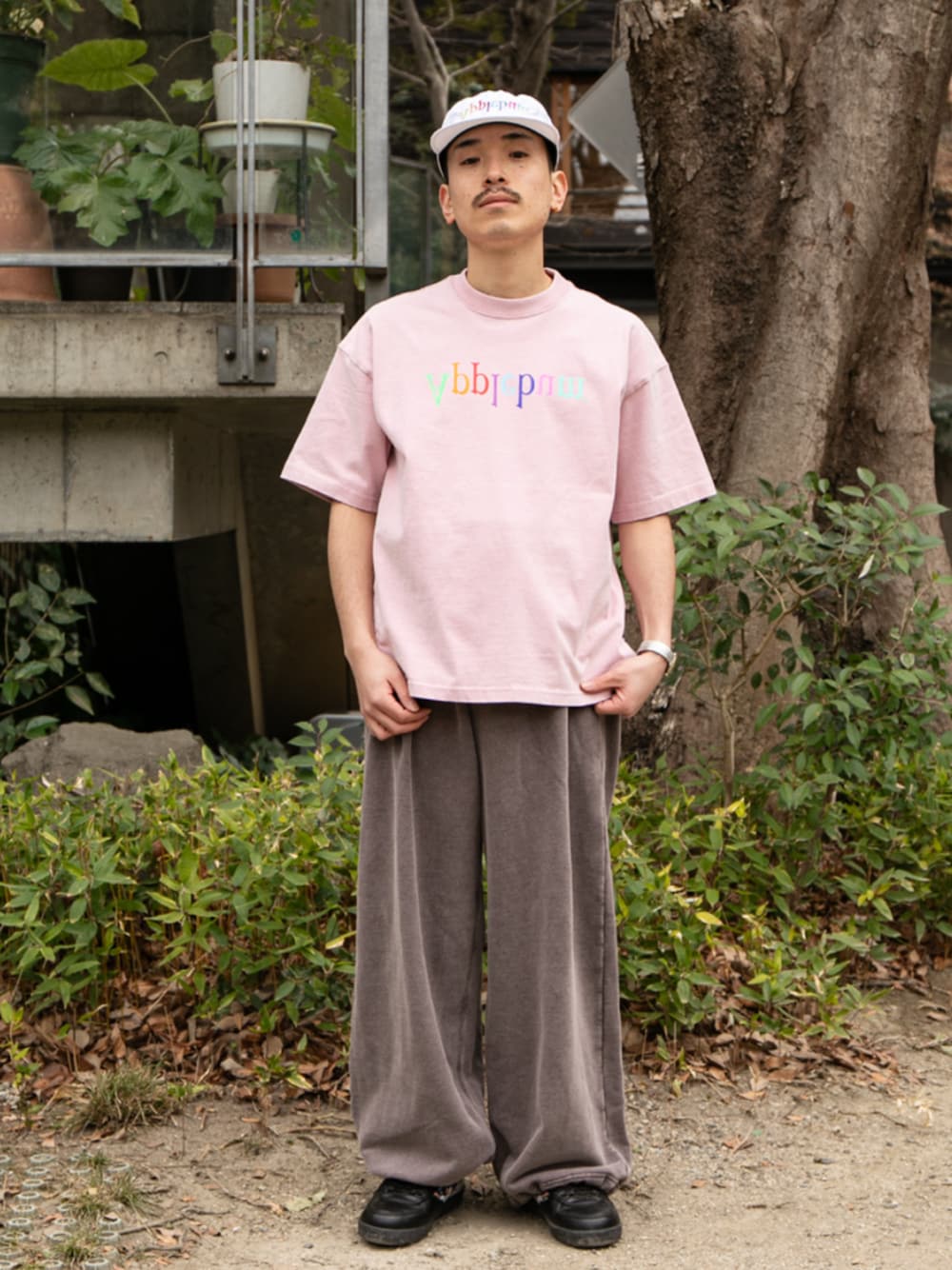 ブラック系のスウェットパンツ、ホワイト系のキャップを着用したメンズの春コーディネートの1枚目の写真