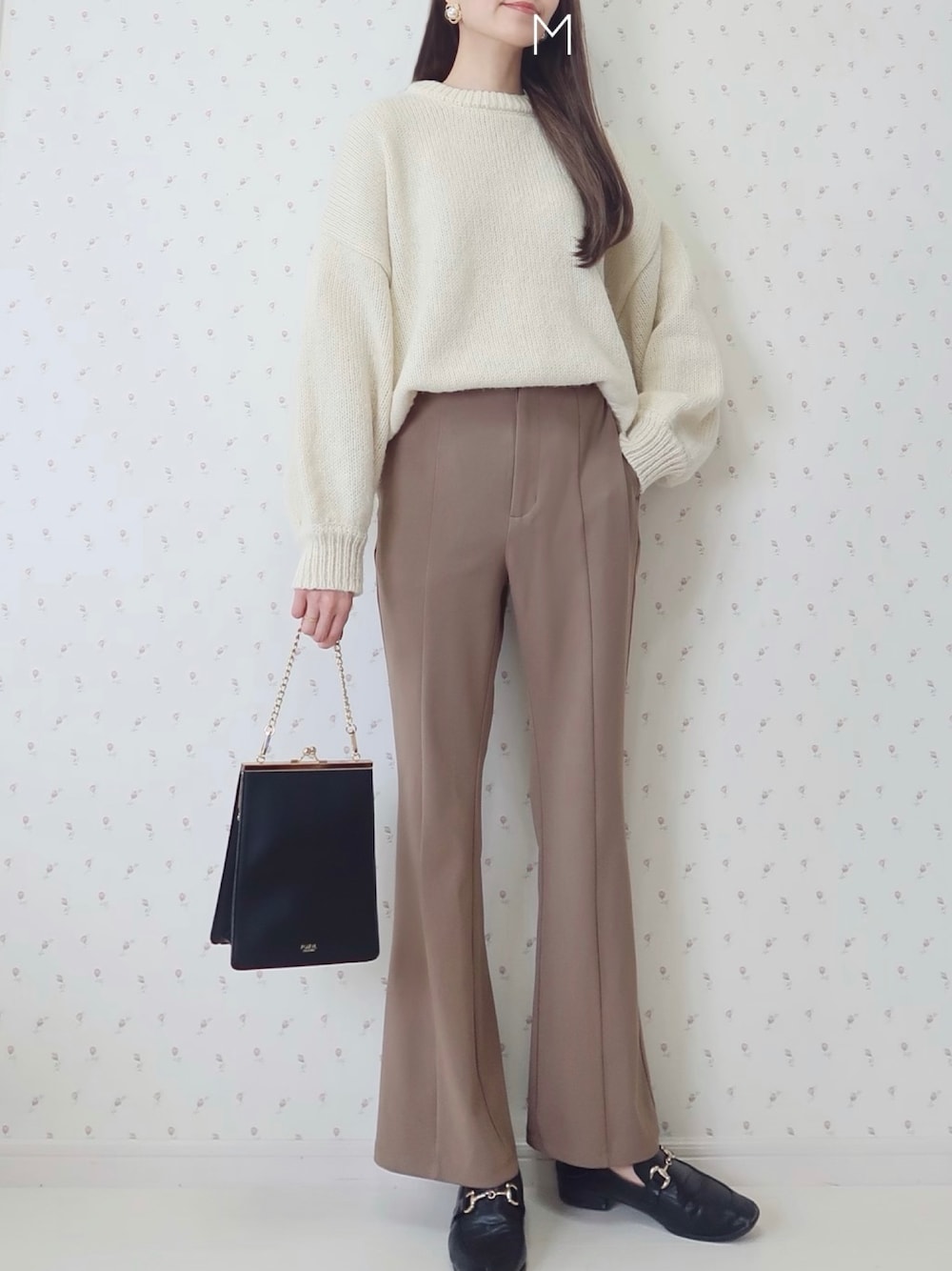 ブラウン系のパンツ、ホワイト系のニット/セーター、ブラック系のショルダーバッグを着用したレディースの冬コーディネートの1枚目の写真