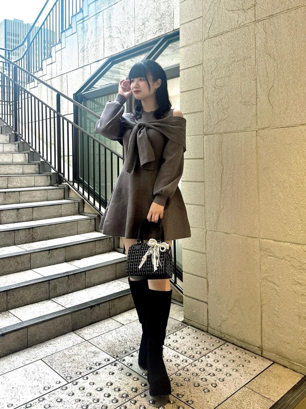 ブラック系のブーツ、ブラック系のボストンバッグ、グレー系のワンピースを着用したレディースの秋コーディネートの1枚目の写真