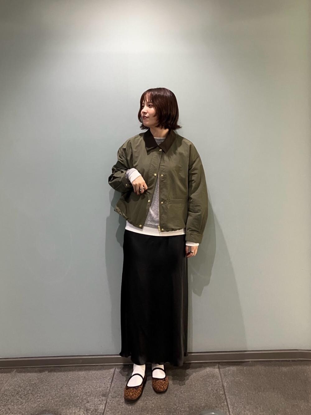 グレー系のTシャツ/カットソー、グリーン系のその他アウター、ブラック系のスカートを着用したレディースの秋コーディネートの1枚目の写真