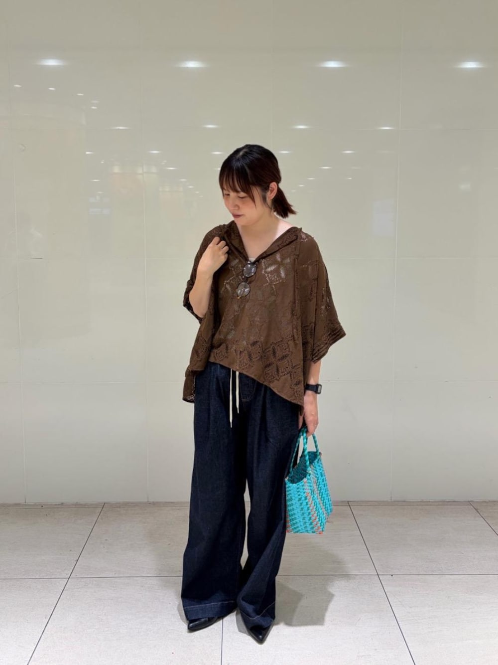 ブルー系のかごバッグ、ブルー系のデニムパンツ、ブラウン系のシャツ/ブラウスを着用したレディースの夏コーディネートの1枚目の写真
