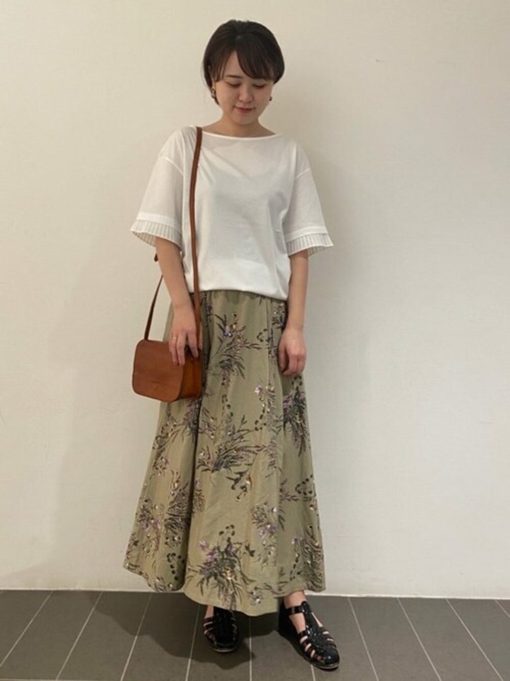 ホワイト系のTシャツ/カットソー、ベージュ系のスカート、イエロー系のショルダーバッグを着用したレディースの夏コーディネートの1枚目の写真