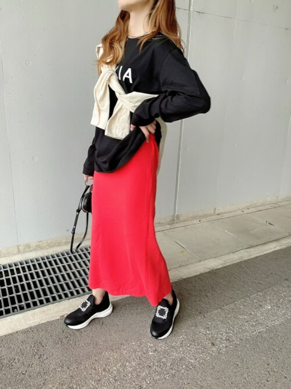 ブラック系のスニーカーを着用したレディースの秋コーディネートの1枚目の写真