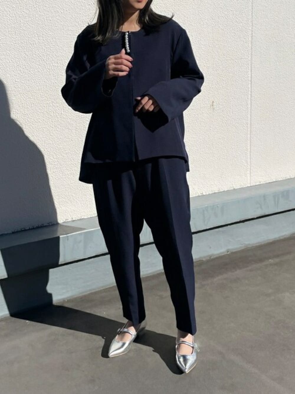 ブルー系のスーツセット、シルバー系のパンプスを着用したレディースの冬コーディネートの1枚目の写真