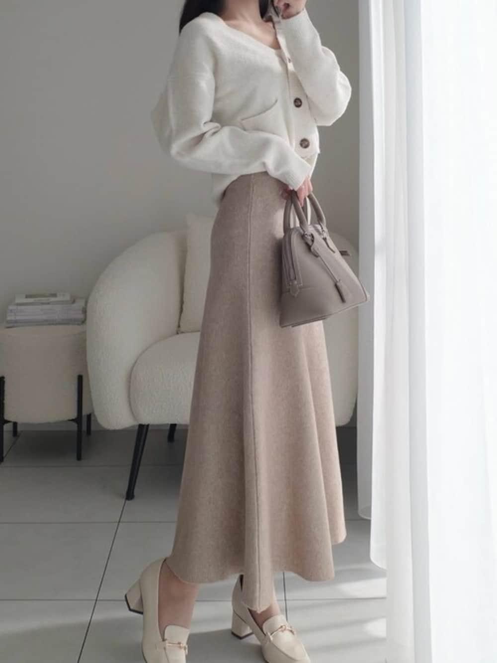 ホワイト系のパンプスを着用したレディースの冬コーディネートの1枚目の写真