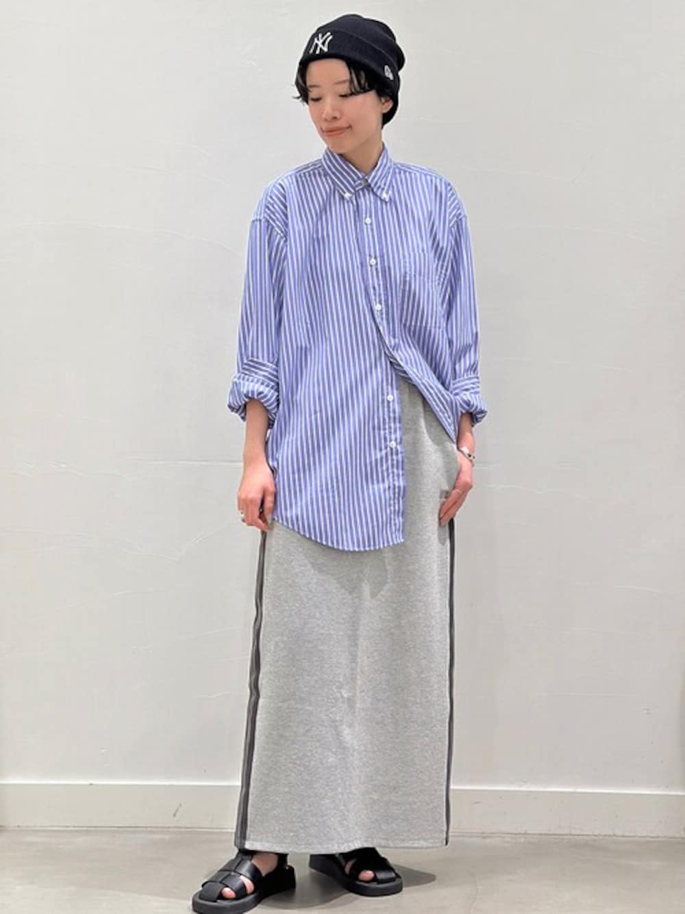 グレー系のスカート、ブルー系のシャツ/ブラウス、ブラック系のサンダルを着用したレディースの春コーディネートの1枚目の写真