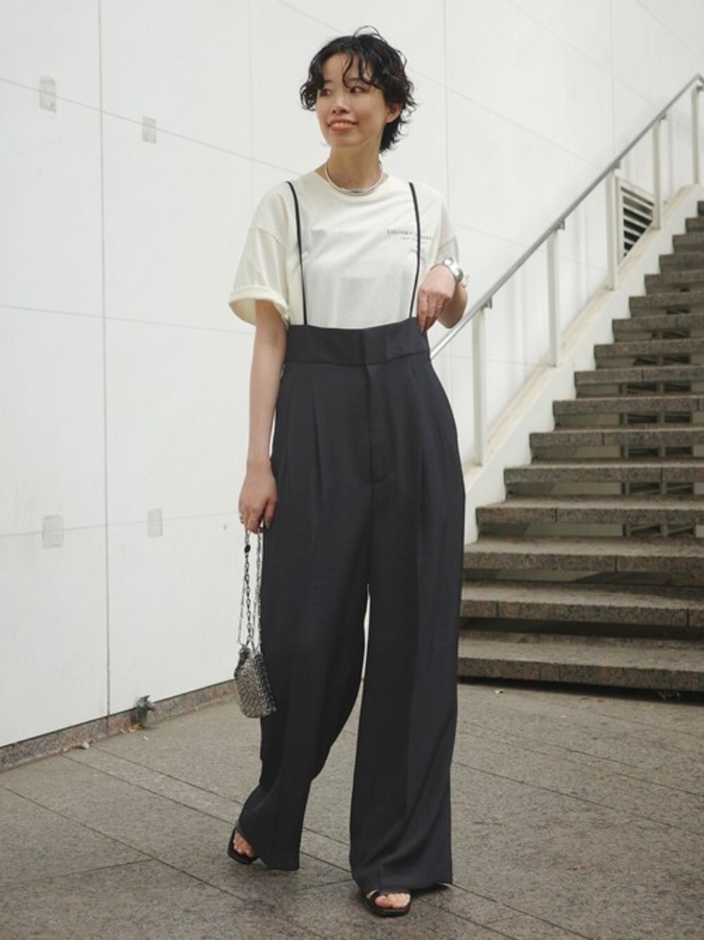 ホワイト系のTシャツ/カットソー、ブラック系のスラックス、ブラック系のサンダルを着用したレディースの春コーディネートの1枚目の写真