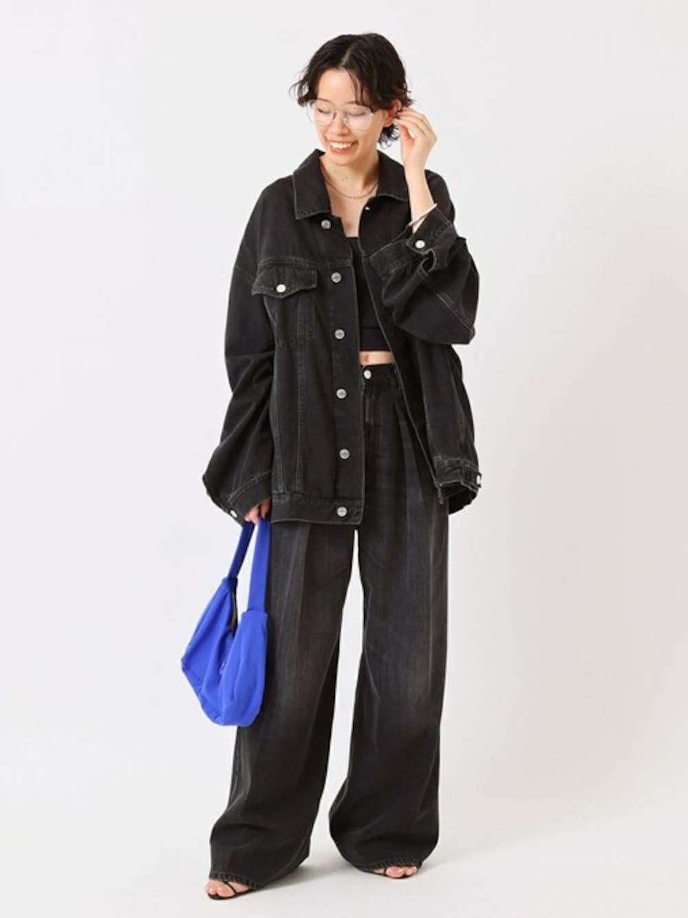 ブラック系のデニムジャケット、ブラック系のデニムパンツ、ブルー系のハンドバッグを着用したレディースの夏コーディネートの1枚目の写真