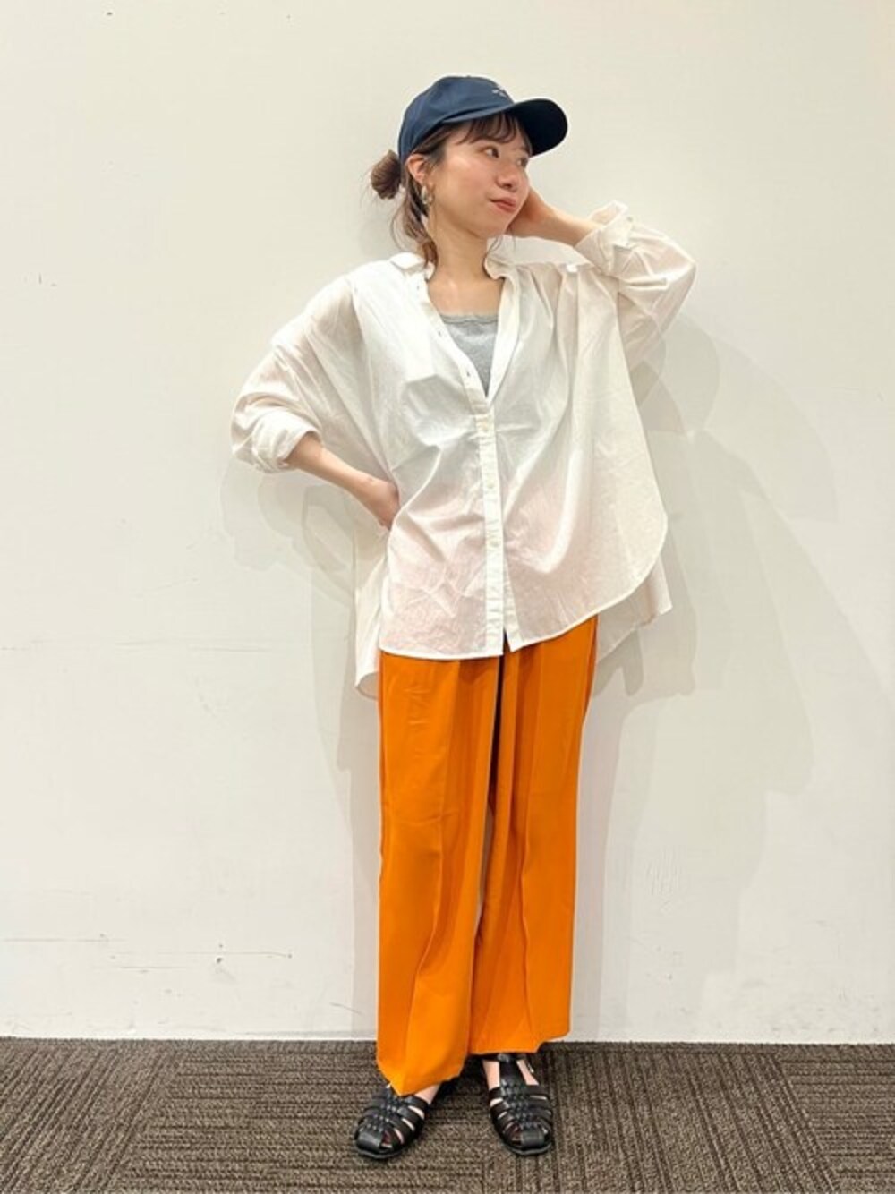 オレンジ系のその他パンツ、ホワイト系のシャツ/ブラウス、ブラック系のサンダルを着用したレディースの春コーディネートの1枚目の写真